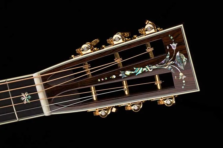 closeup of a vintage acoustic guitar's slotted headstock and tuners