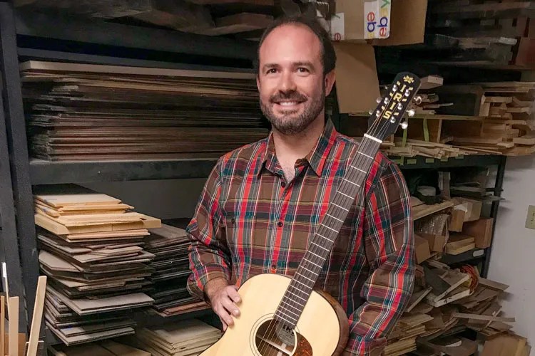 Luthier Adam Buchwald poses with an Iris guitar.