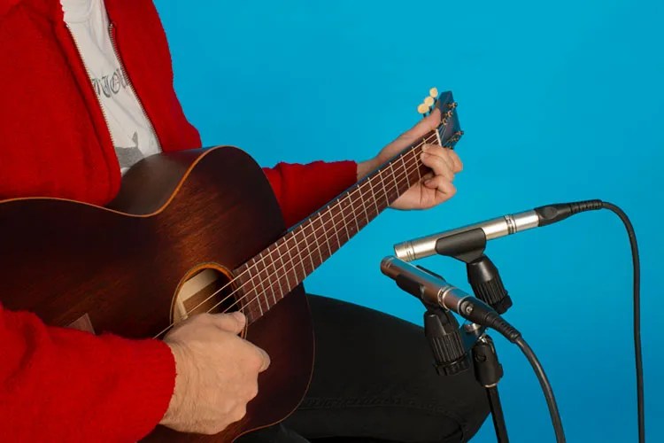 A guitar next to a digital recorder