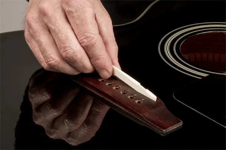 bone saddle on a guitar