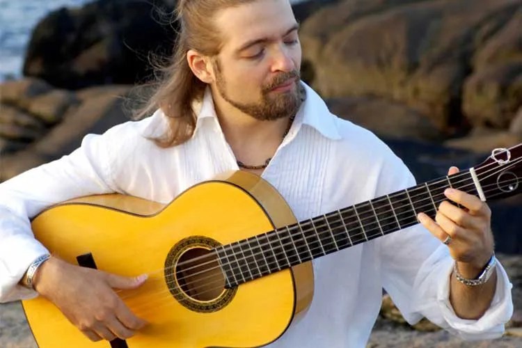 Juanito Pascual playing a classical guitar.