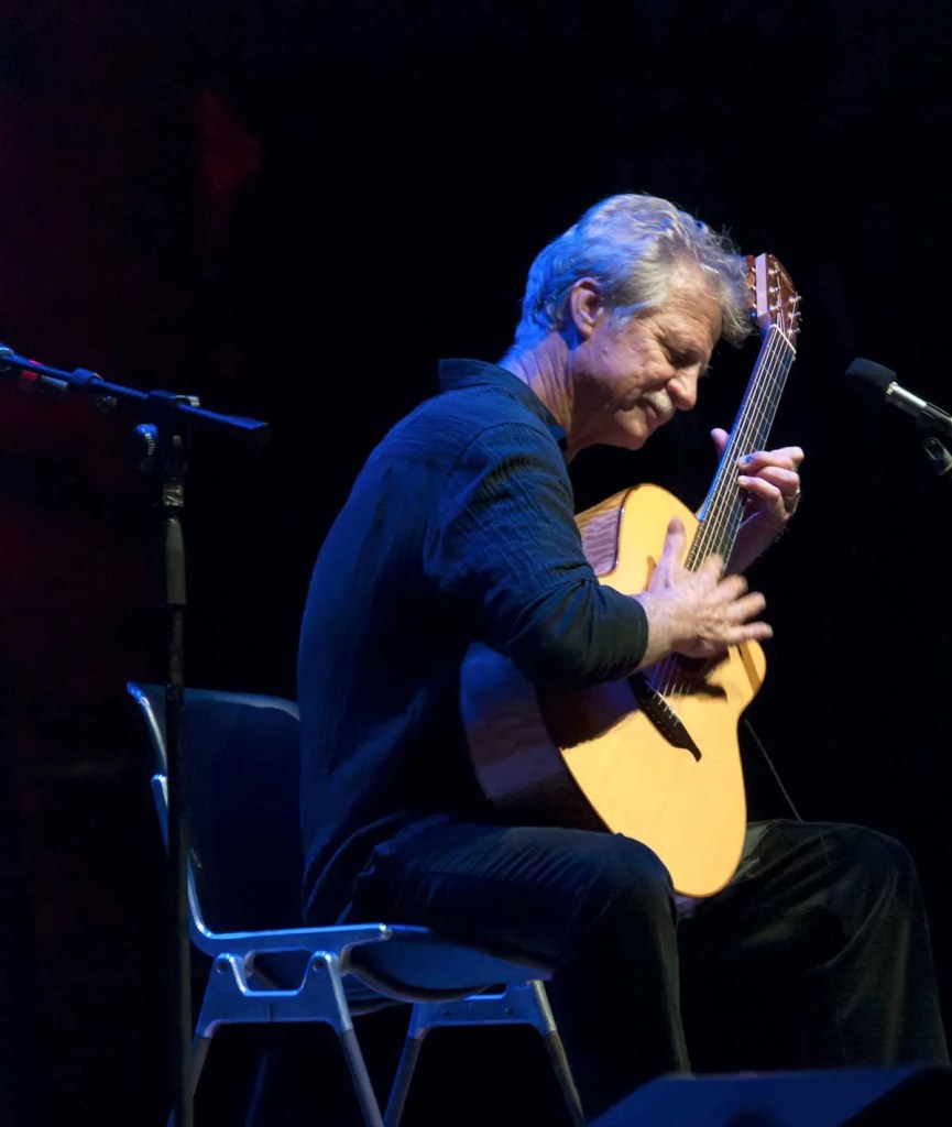 Alex De Grassi playing guitar onstage