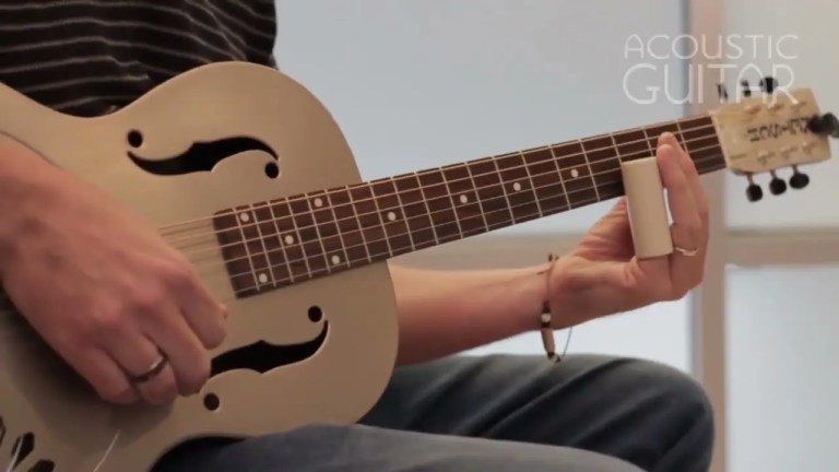 acoustic guitar being played with slide