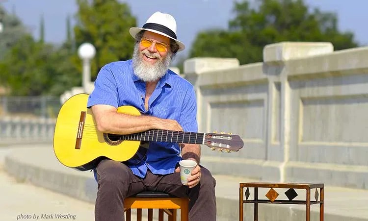 Andrew York with guitar on a bridge