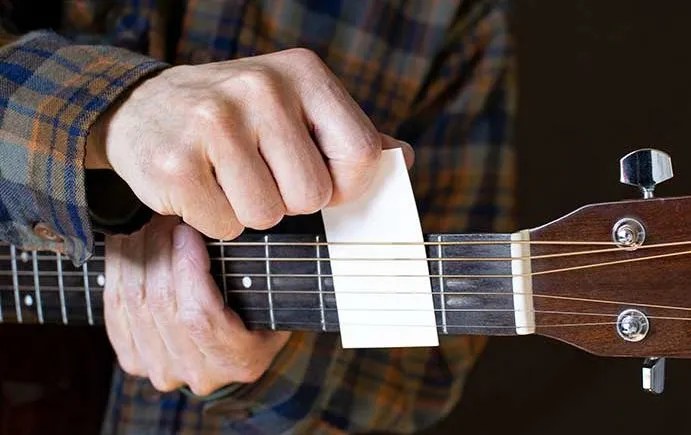 biz card under guitar strings