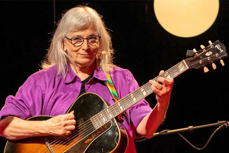 Cathy Fink playing acoustic guitar