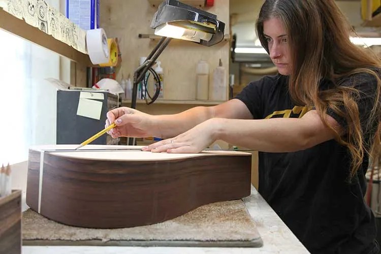 Olivia Elia centering an acoustic guitar