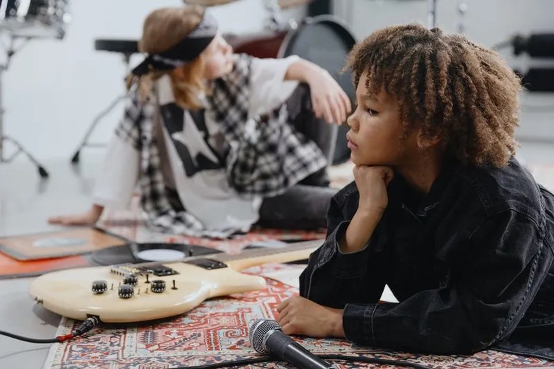 two friends pose in a music studio with their guitars