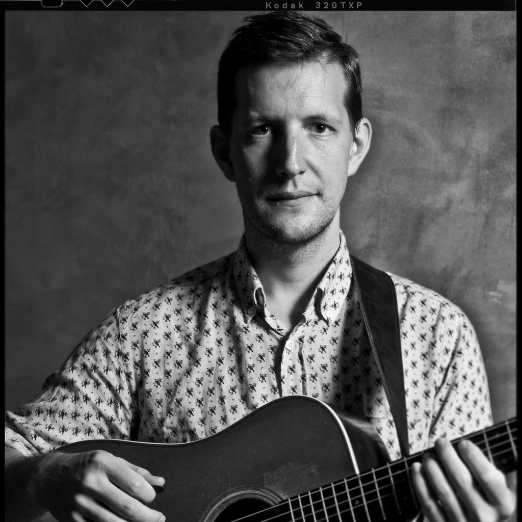 photo of Chris Eldridge holding a guitar