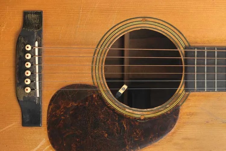 Closeup of bridge, soundhole, and pickguard of Jerry Garcia's Martin D-28 acoustic guitar