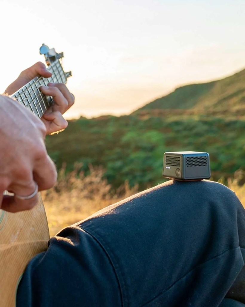 Audigo wireless microphone balanced on a guitarist's knee