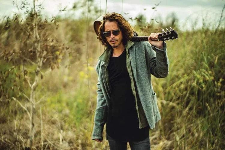 Chris Cornell holds his acoustic guitar.