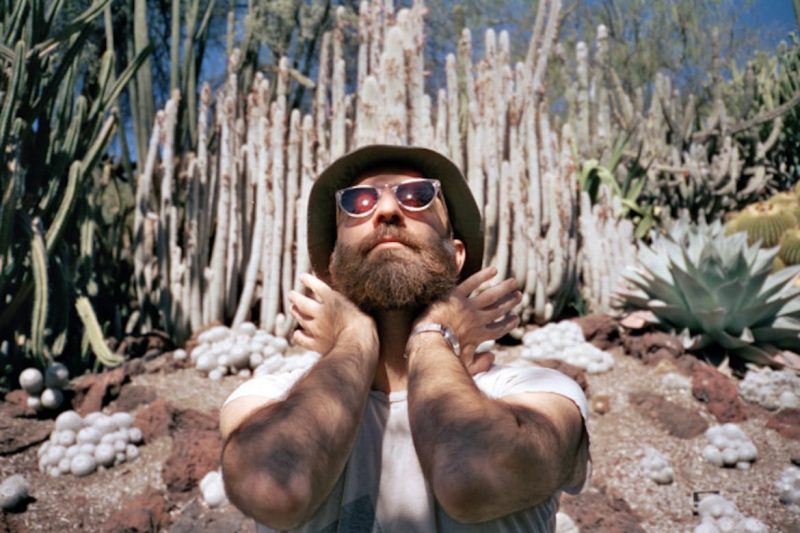 guitarist Deniz Cuylan standing in front of cactus