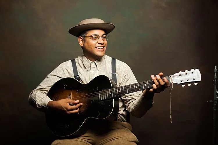 Dom Flemons playing acoustic guitar