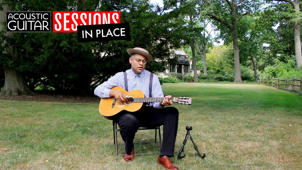 Dom Flemons outdoors playing acoustic guitar