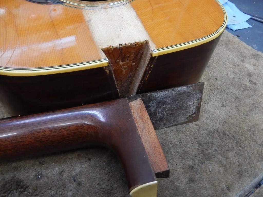 closeup of a martin acoustic guitar neck joint with the neck detached