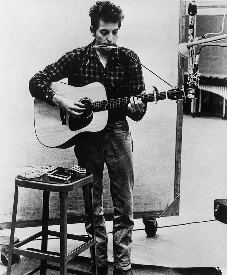 Bob Dylan with acoustic guitar in a recording studio