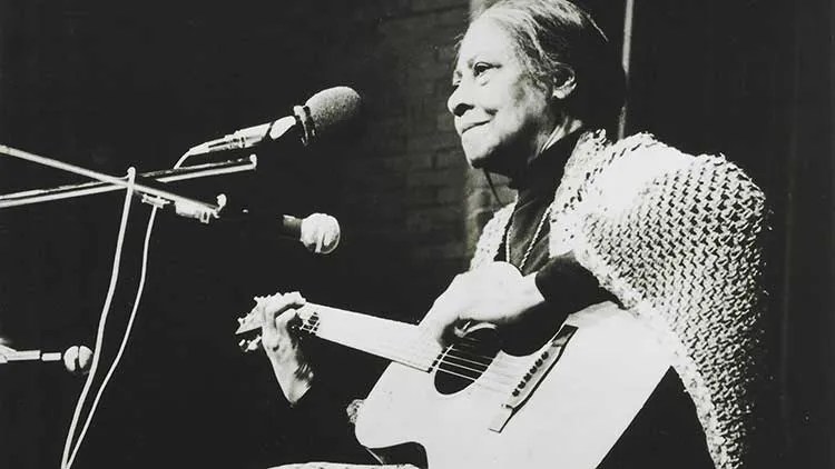 guitarist Elizabeth Cotten performing with a shawl over her shoulders