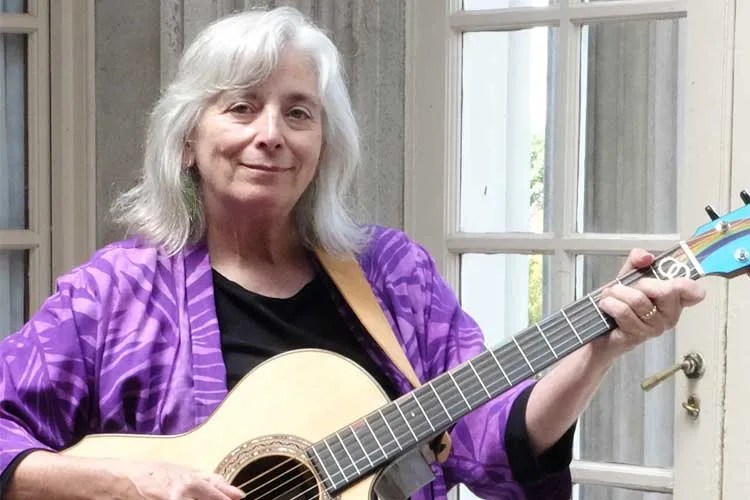 Cathy Fink holding acoustic guitar