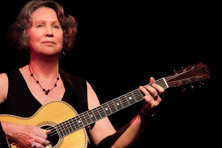 Mary Flower playing an acoustic guitar