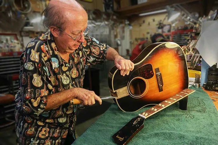 Frank Ford at the work bench, repairing a Gibson acoustic guitar, Courtesy of Gryphon Stringed Instruments