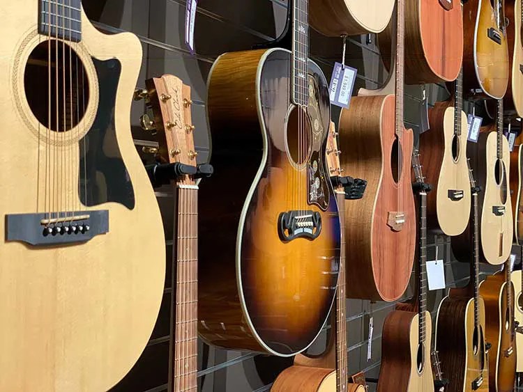 acoustic guitars hanging on a wall in the store