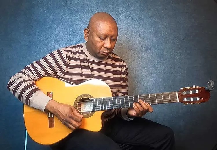 ron jackson seated with a guitar for guitar lesson on harmonic and melodic minor scales