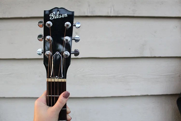 close up of vintage gibson headstock being hung on a wall