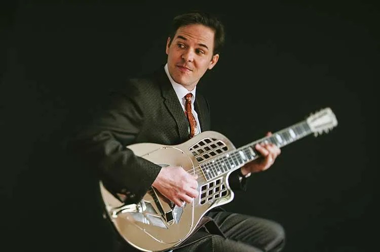 Portrait of jazz guitarist Greg Ruby with resonator guitar.