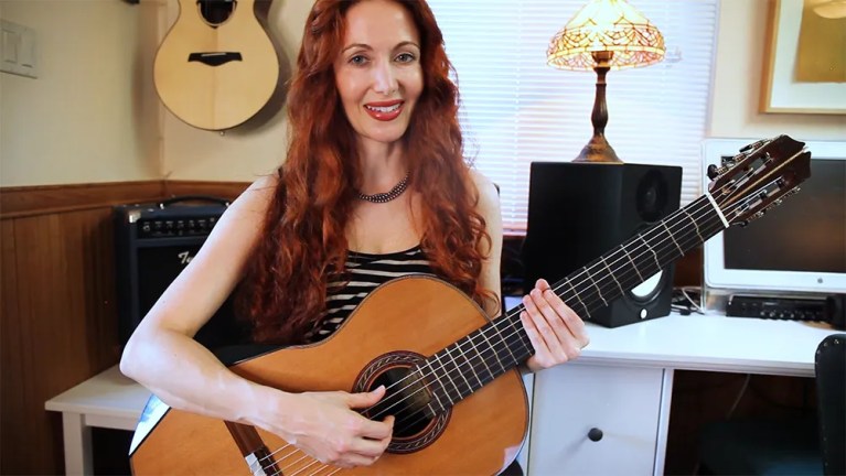 Guitarist Gretchen Menn playing arpeggios on acoustic guitar.