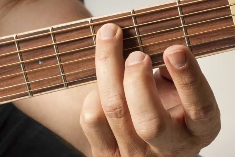 a person demonstrating the hammer-on technique on a guitar