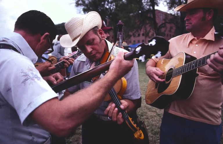 Men playing bluegrass music on guitars and fiddles in the 1970s-photo-Terry Eiler