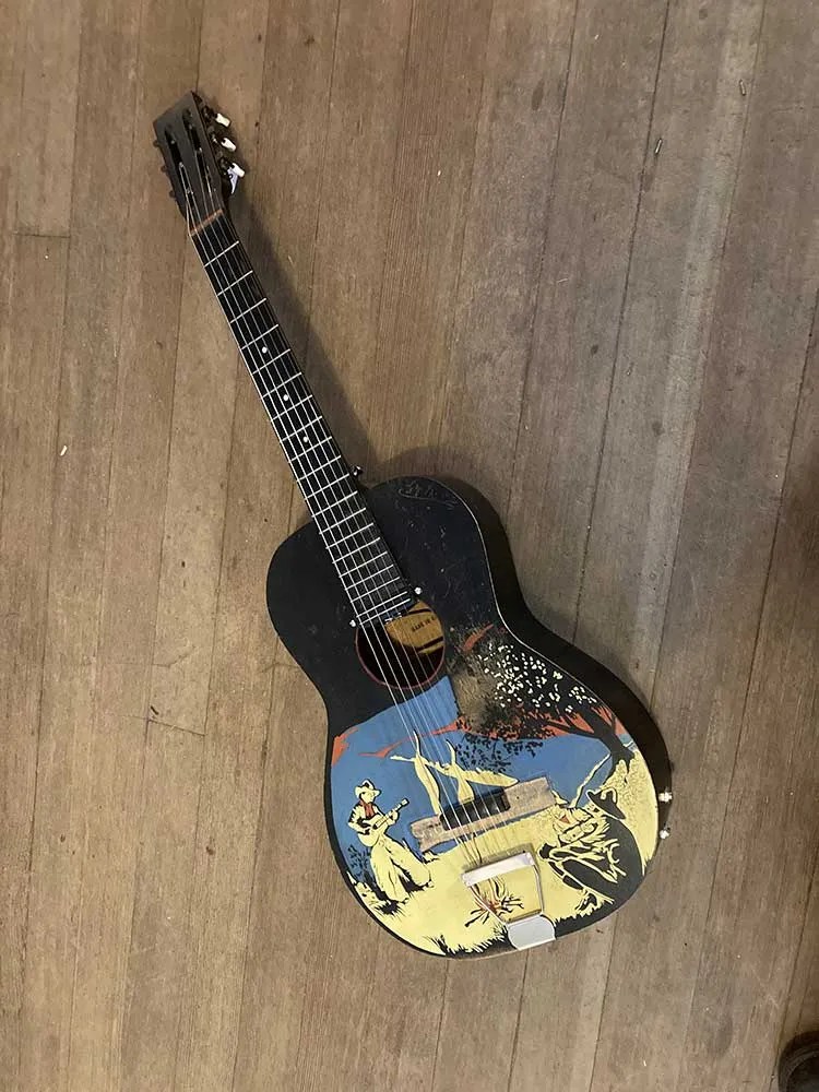 Vintage cowboy guitar modified with a rubber bridge on display at Reuben Cox’s Old Style Guitar Shop in Los Angeles.