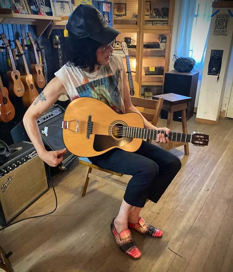 A customer checks out an instrument in Reuben Cox's Old Style Guitar Shop.