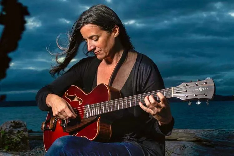 Jamie Stillway playing guitar outdoors