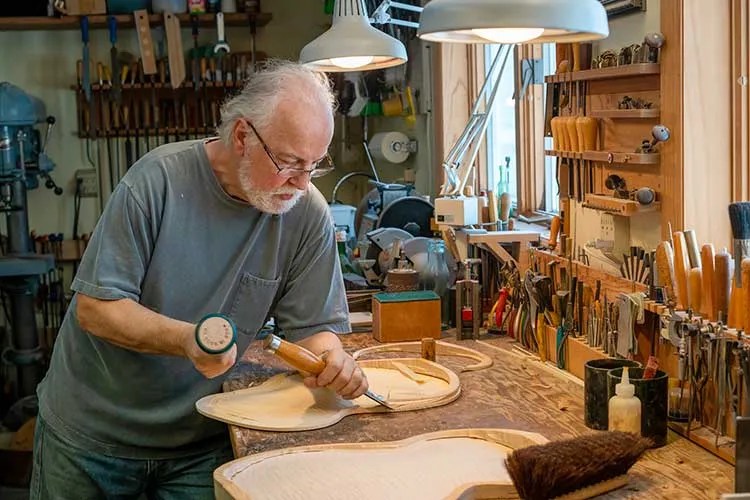 John Monteleone shapes a guitar in his workshop