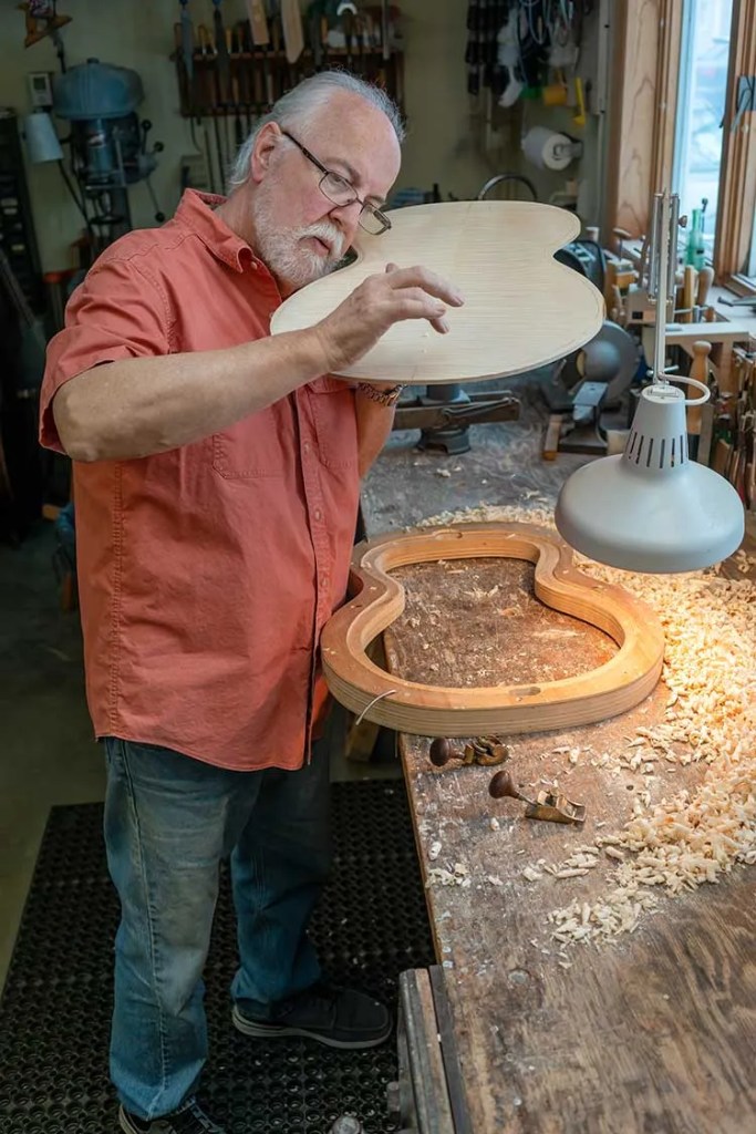 John Monteleone tests a guitar top in his workshop. Photo by Rod Franklin