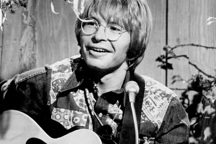 John Denver performing on guitar