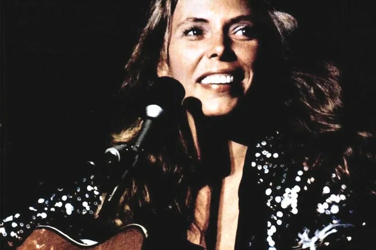 Joni Mitchell singing into a microphone