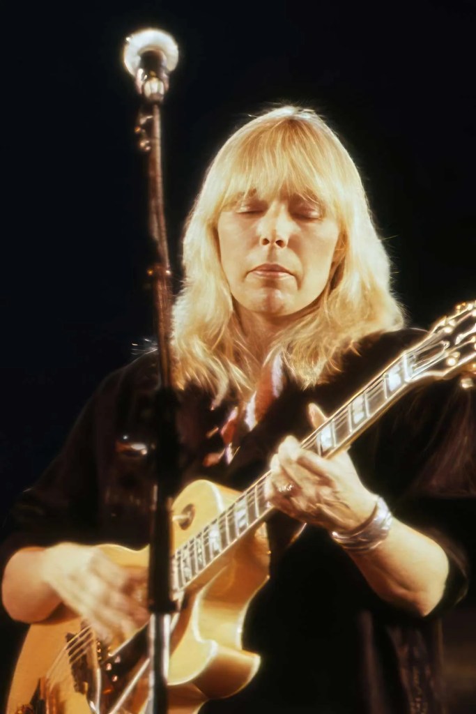 Joni Mitchell playing guitar in 1983