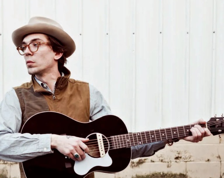 Justin Townes Earle poses with a black and white guitar