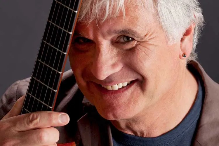 A smiling Laurence Juber with guitar. Photo by Kenna Love