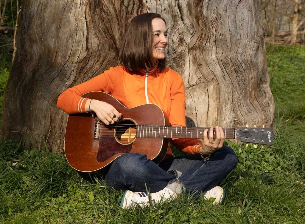 Margaret-Glaspy_playing-acoustic-guitar-in -front-of-large-tree-trunk-photo-Ebru-Yildiz_140-Edit_300DPI