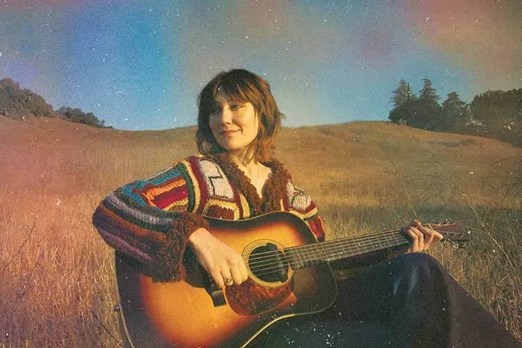 molly tuttle with acoustic guitar outdoors