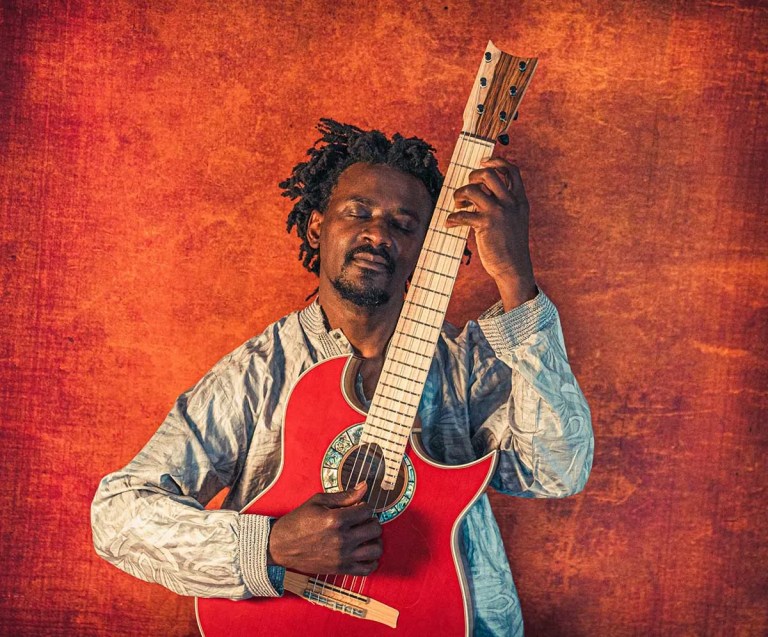 Niwel Tsumbu with guitar. photo by Matthew Hurrell O’Conor