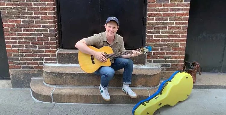 Noah Reid of Schitt's Creek with Linda Manzer's Sunflower Guitar for Ukraine