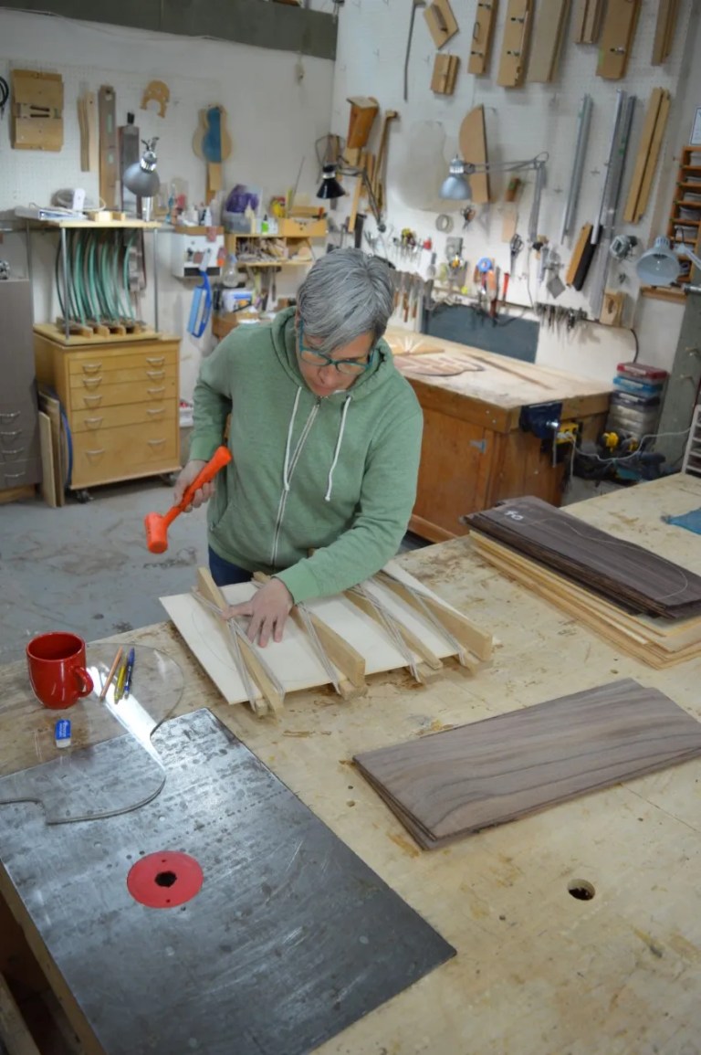 Shelley Park glues the center seam of a new soundboard