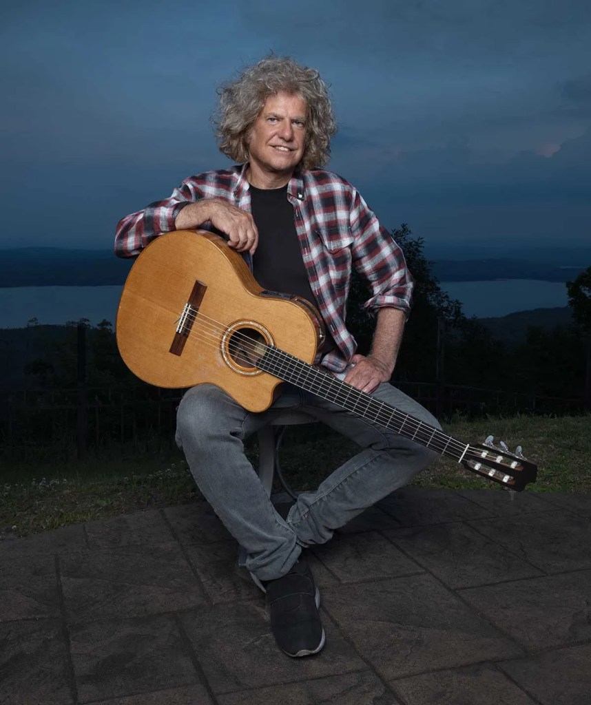 Pat Metheny seated with his guitar. Photo by James Katz