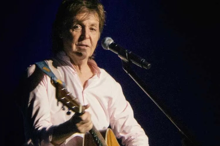 Paul McCartney playing acoustic guitar