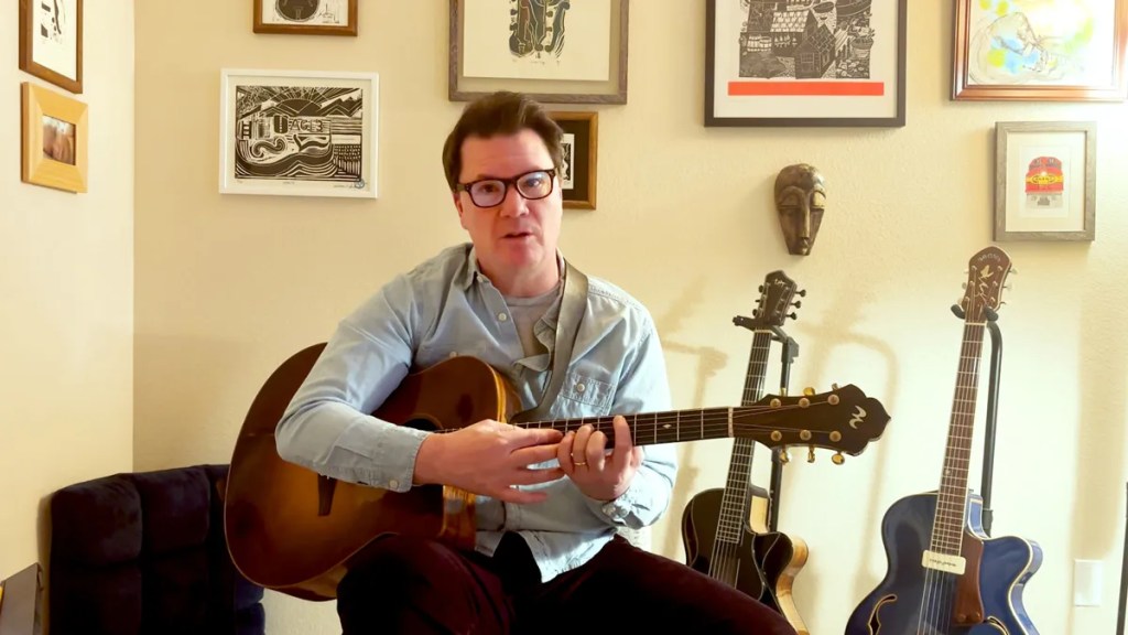 Guitarist Sean McGowan seated with guitar